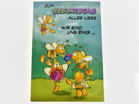 Geburtstagskarte mit fröhlichen Bienen, die Geschenke und Blumen halten. Der Text "Zum Geburtstag alles Liebe wir sind uns einig" steht prominent auf der Karte. Hersteller: Juwelier Harnisch.