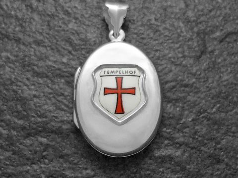Silbernes Medaillon von Juwelier Harnisch, Berlin, mit dem Wappen von Tempelhof. Das Wappen zeigt ein rotes Kreuz auf silbernem Grund und ist kunstvoll gestaltet.