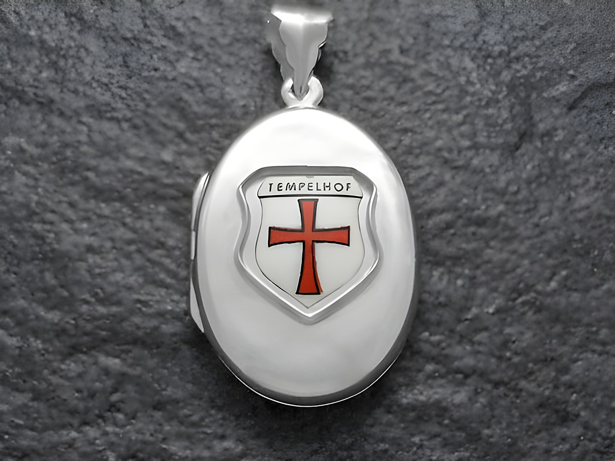 Silbernes Medaillon von Juwelier Harnisch, Berlin, mit dem Wappen von Tempelhof. Das Wappen zeigt ein rotes Kreuz auf silbernem Grund und ist kunstvoll gestaltet.