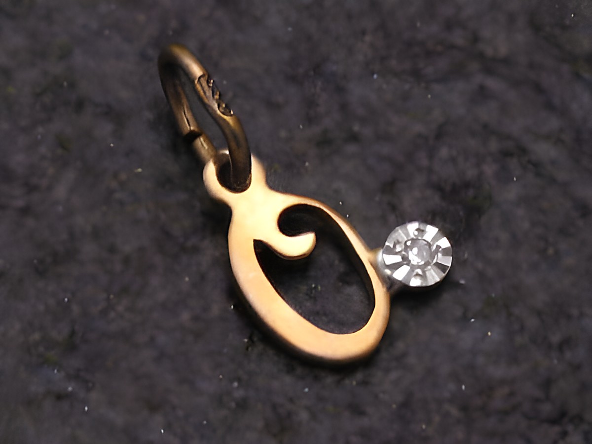 Goldener Anhänger in O-Form mit einem Diamanten, Hersteller Juwelier Harnisch, elegant und zeitlos gestaltet, ideal als persönliches Schmuckstück oder Geschenk.