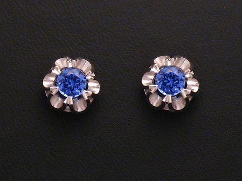 Ohrringe mit synthetischen Saphiren in blauer Farbe, gefasst in Weißgold 585. Die Ohrstecker zeichnen sich durch ein florales Design aus. Hersteller ist Juwelier Harnisch.