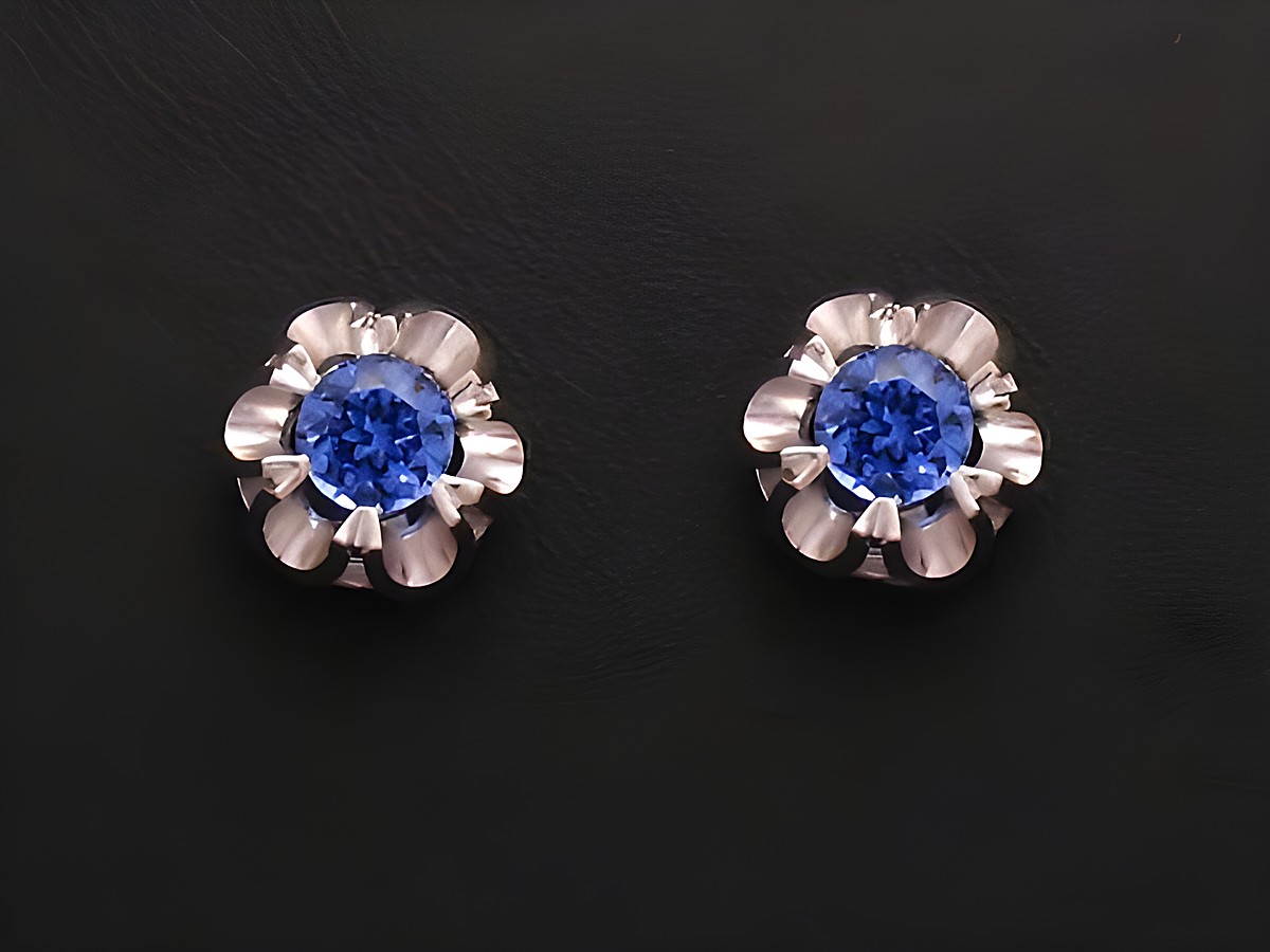 Ohrringe mit synthetischen Saphiren in blauer Farbe, gefasst in Weißgold 585. Die Ohrstecker zeichnen sich durch ein florales Design aus. Hersteller ist Juwelier Harnisch.