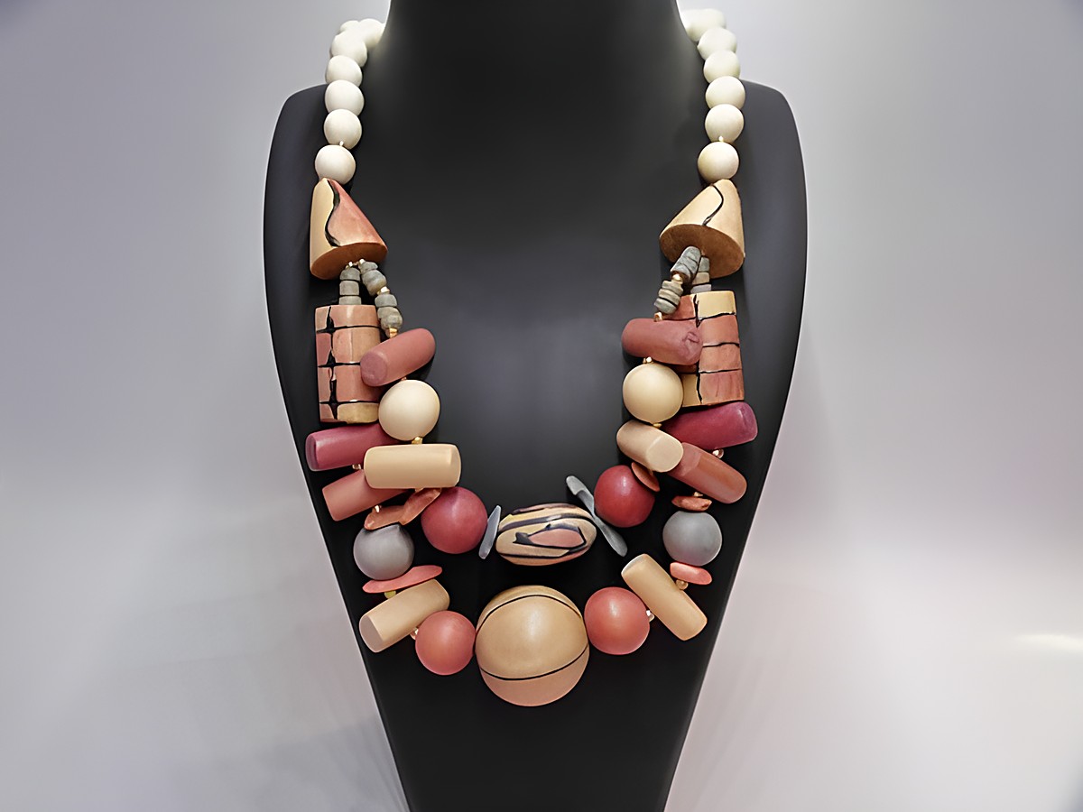 Bunte Holzkette mit einer Länge von 60 cm, hergestellt von Juwelier Harnisch, featuring diverse Formen und Farben, ideal für ein auffälliges Schmuckstück.