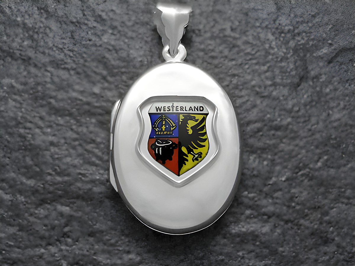 Ein silbernes Medaillon mit dem Stadtwappen von Westerland, das einen bunten Schild mit einer Krone und einem Löwen zeigt, hergestellt von Juwelier Harnisch in Schleswig-Holstein.