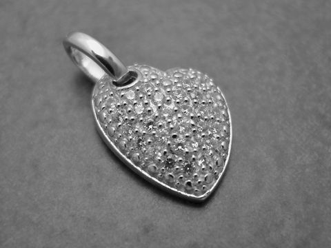 Herz mit Zirkonia in asymmetrischer Form, gefertigt aus Sterling Silber. Der Anhänger zeigt eine strukturierte Oberfläche und verleiht eleganten Schmuckstücken einen besonderen Akzent.