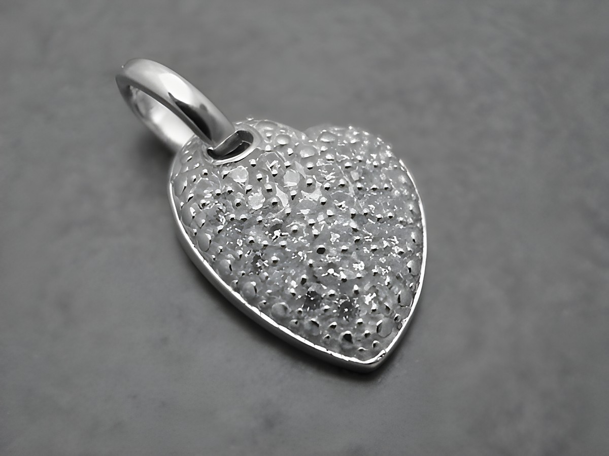 Herz mit Zirkonia in asymmetrischer Form, gefertigt aus Sterling Silber. Der Anhänger zeigt eine strukturierte Oberfläche und verleiht eleganten Schmuckstücken einen besonderen Akzent.