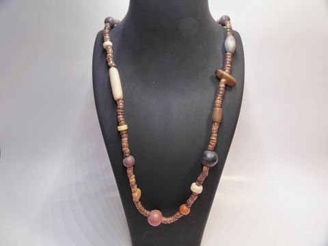 Bunte Holzkette Multiform 31 mm 90 cm von Juwelier Harnisch auf einem Schmuckdisplay, kombiniert verschiedene Holzperlen in unterschiedlichen Farben und Formen.