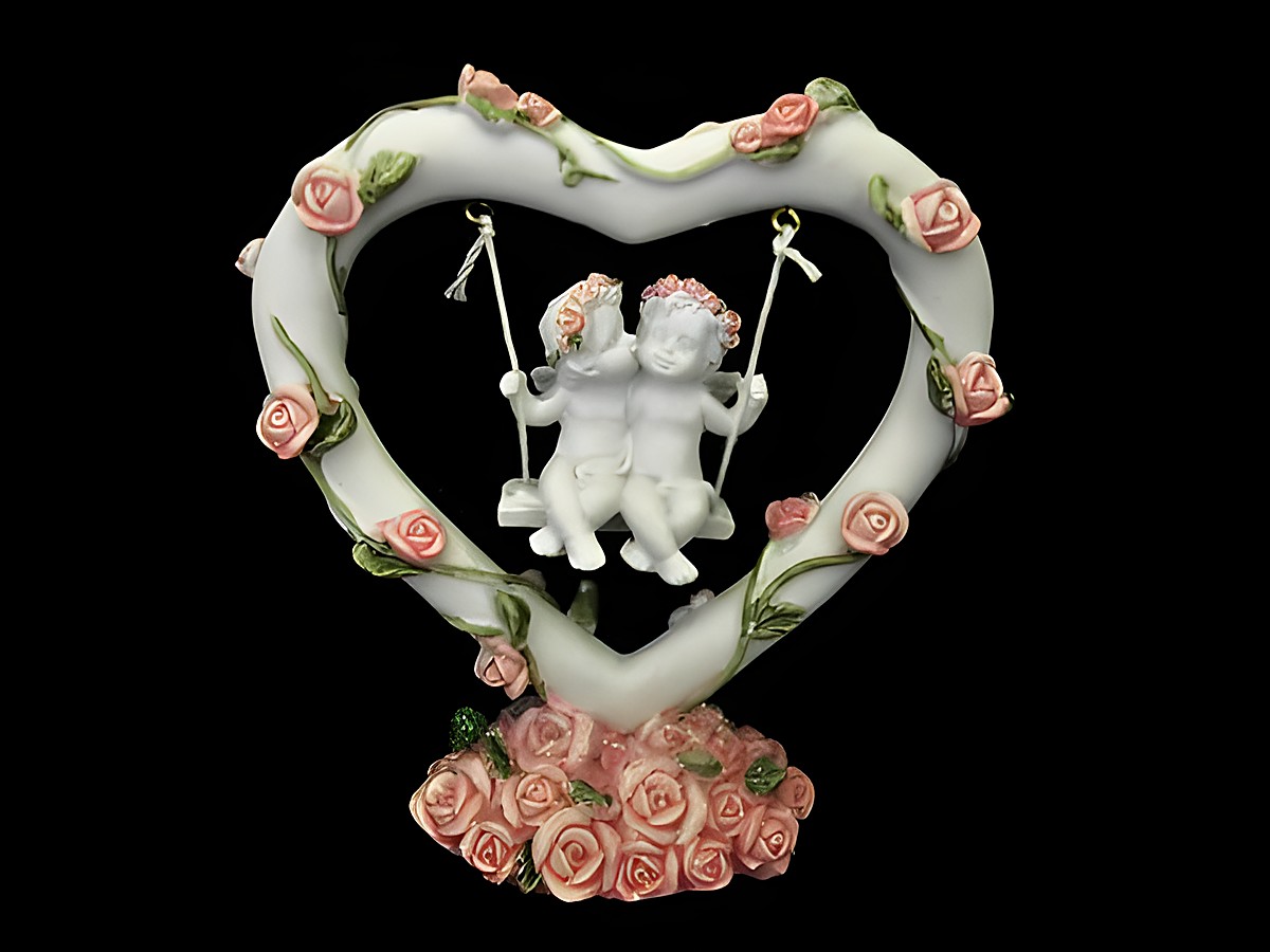 Eine liebevoll gestaltete Schutzengel Figur in Herzform, die zwei engelliche Kinder auf einer Schaukel zeigt, umgeben von zarten Rosen. Hersteller Juwelier Harnisch.