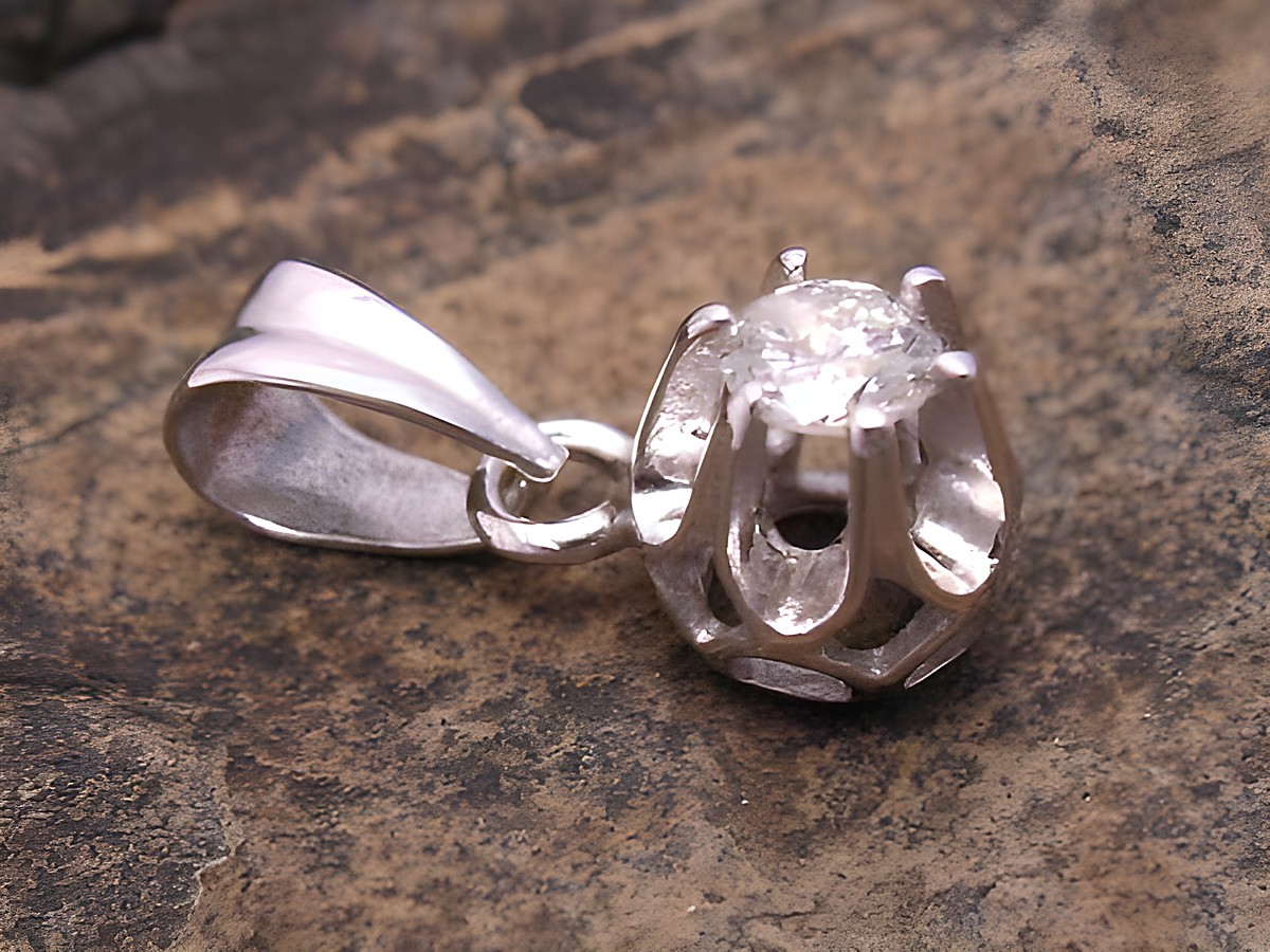 Weißgold Anhänger kunstvoll gefertigt aus Weißgold 585 mit einem Brillant, Hersteller Juwelier Harnisch, der Diamanten und Brillianten vereint. Elegantes Schmuckstück auf natürlichem Hintergrund.