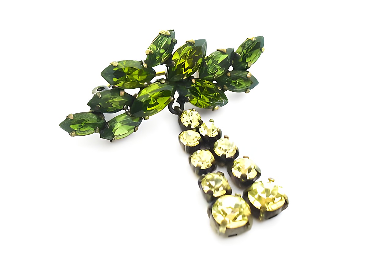 Grüne Strass Brosche im Sexy City Look, hergestellt von Juwelier Harnisch. Funkelnde grüne und gelbe Strasssteine, elegantes Design für stilvolle Akzente.