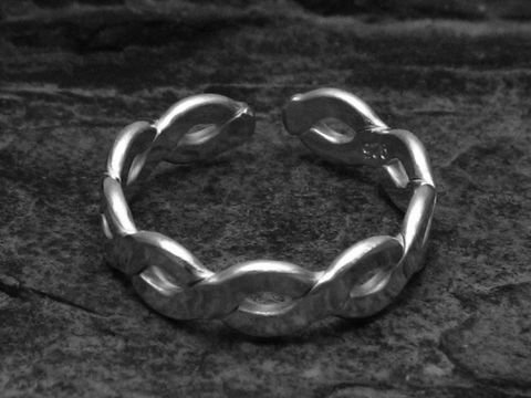 Silberring DESIGN GEFLOCHTEN in wenig verstellbarer Größe, hergestellt von Juwelier Harnisch, ohne Stein, auf dunklem Hintergrund abgebildet.