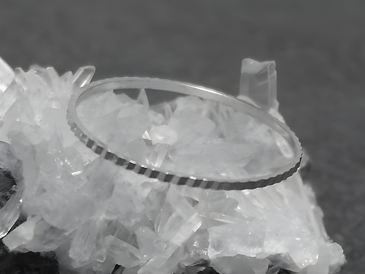 Silber Ring rhodiniert 1mm breit Größe 60 19mm auf einem Bett aus Kristallen, Hersteller Juwelier Harnisch bis Größe 60 19,1. Elegantes, schlichtes Design.