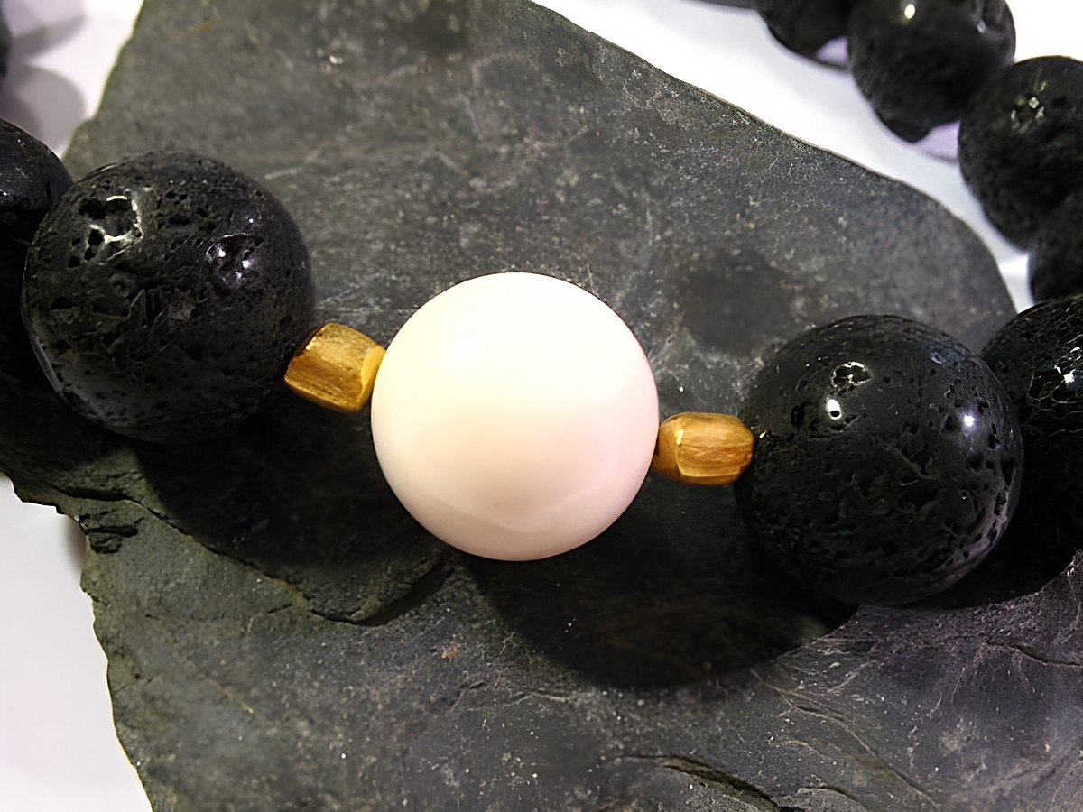 Auf dem Bild ist eine Schmuckkette aus Lava und Opal-Kascholong zu sehen, kombiniert mit goldfarbenen Akzenten. Die Kette hat eine Länge von 48 cm und stammt vom Hersteller Juwelier Harnisch. – Ansicht 2