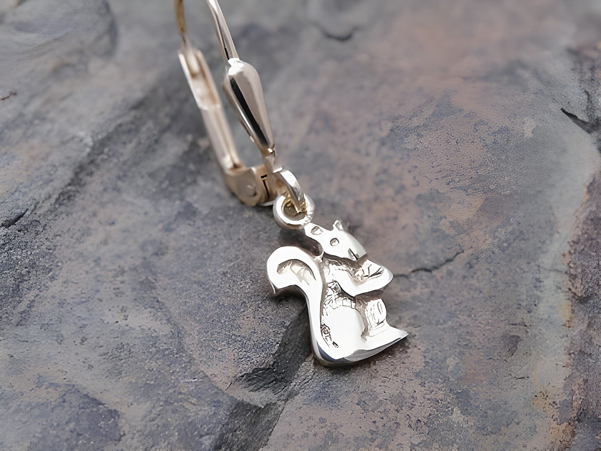 Eichhörnchen Ohrstecker unisex aus Gold, tierisches Design, Einzelohrringe von Juwelier Harnisch, ein Stück, detaillierte Verarbeitung und ansprechende Optik auf steiniger Unterlage.