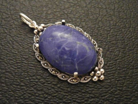 30758-0 Ein silbernes Medaillon mit einem ovalen Cabochon aus lapisblauem Howlith, umrahmt von filigranen Details, hergestellt von Juwelier Harnisch.