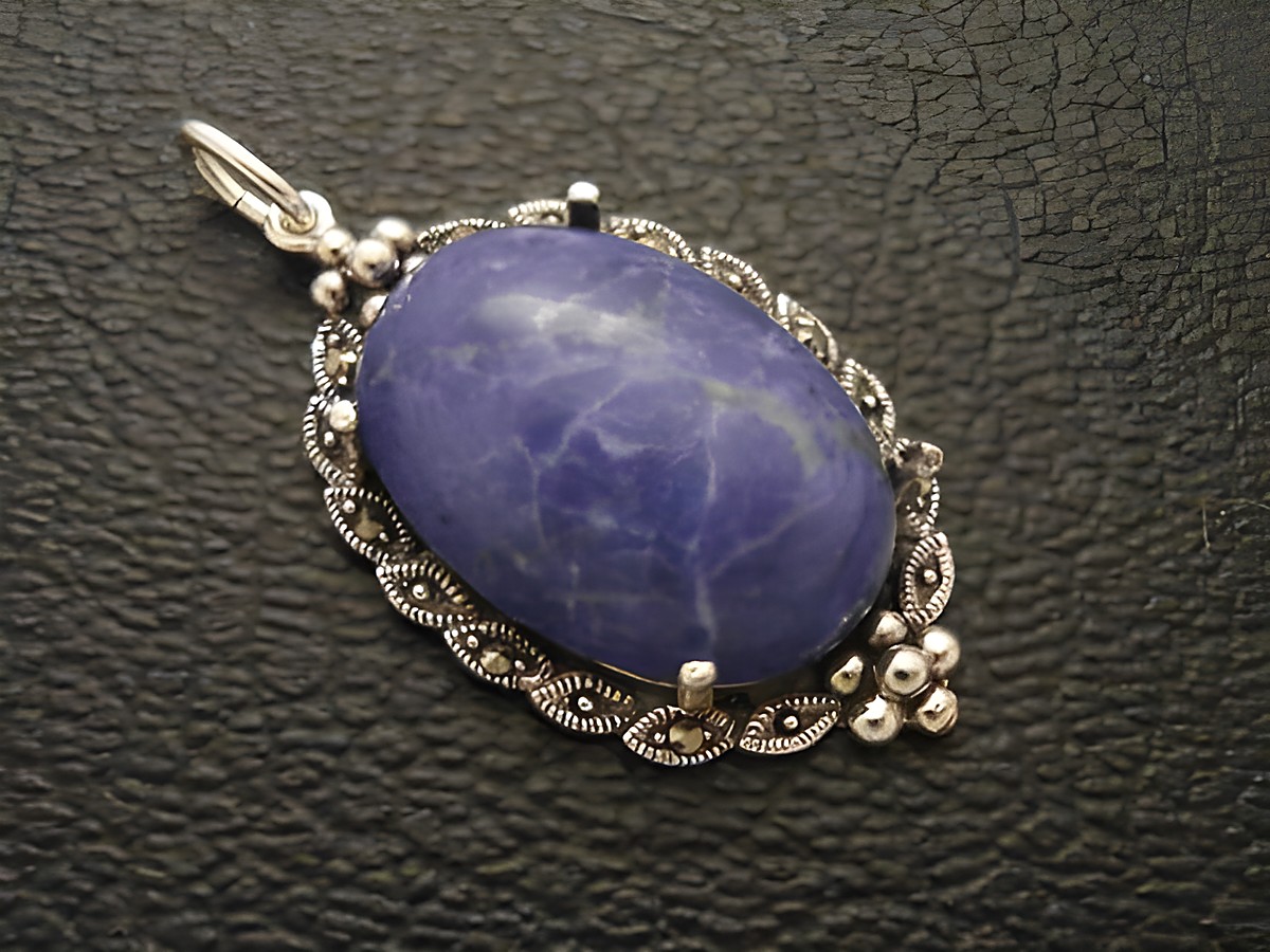 Ein silbernes Medaillon mit einem ovalen Cabochon aus lapisblauem Howlith, umrahmt von filigranen Details, hergestellt von Juwelier Harnisch.