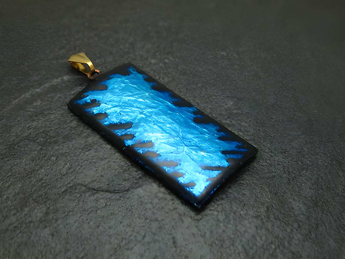 Emaille Anhänger in hellblau mit einer strukturierten Oberfläche und einer goldenen Anhängerschlaufe, Vintage-Stil vom Juwelier Harnisch, ideal für stilvolle Schmuckstücke.