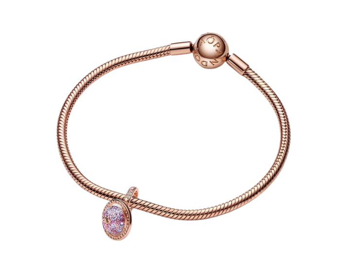 Armband von Pandora in Roségold mit einem Charm in Form des Planeten Saturn, ausgestattet mit einem Steinmix in lila Tönen, elegant und modern gestaltet, ideal für Schmuckliebhaber.