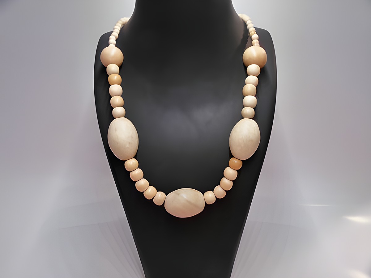 Holzkette Multiform 30 mm naturbraun 60 cm Holz Schmuck von Juwelier Harnisch, bestehend aus verschiedenen Holzperlen in unterschiedlichen Größen und Formen, präsentiert auf einem schwarzen Schmuckständer.
