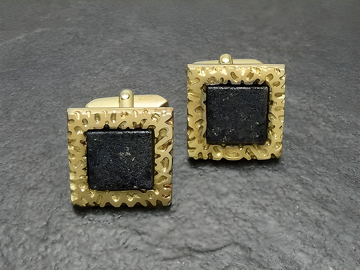 Vergoldete Manschettenknöpfe mit quadratischem, schwarzem Stein, Hersteller Juwelier Harnisch, goldfarbener Rahmen mit feinem Muster. Ideal für elegante Anlässe.