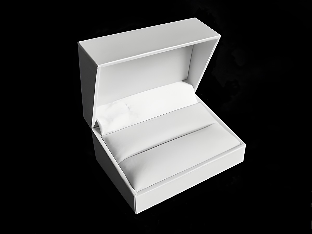 Geschenkschachtel für Trauringe und Manschettenknöpfe in klassischem Weiß, hergestellt von Juwelier Harnisch, öffnet sich und zeigt weiche Polsterung im Inneren zur sicheren Präsentation.
