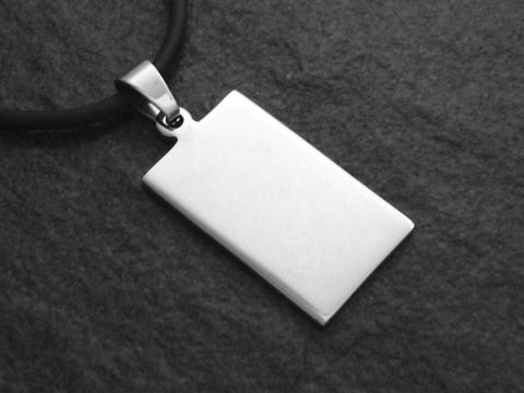 Edelstahl Anhänger mit einer Gravurfläche von 31,6 mm, hergestellt von Juwelier Harnisch, hängt an einem schwarzen Band und hat eine rechteckige, schlichte Form.
