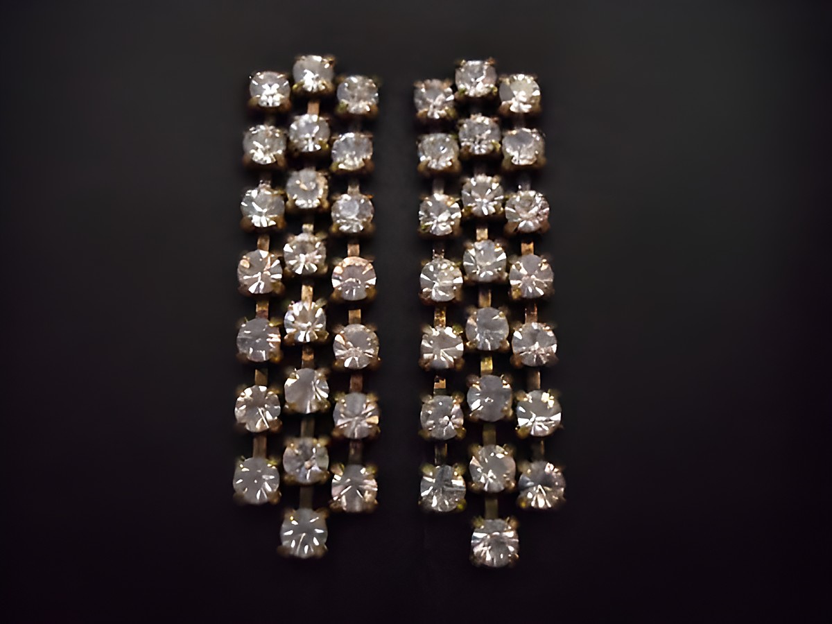 Elegante goldfarbene Ohrstecker mit Strass, gefertigt vom Juwelier Harnisch, zeigen ein funkelndes Design mit mehreren klaren Steinen in einer geschmackvollen Anordnung.