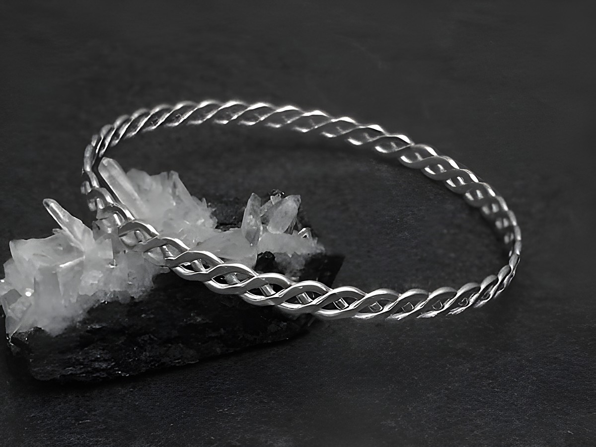 Silber Armreifen - verflochten - 5,3 mm - 20 cm, Hersteller: Juwelier Harnisch, elegante und zeitlose Schmuckstück auf schwarzem Untergrund, ideal für jeden Anlass.