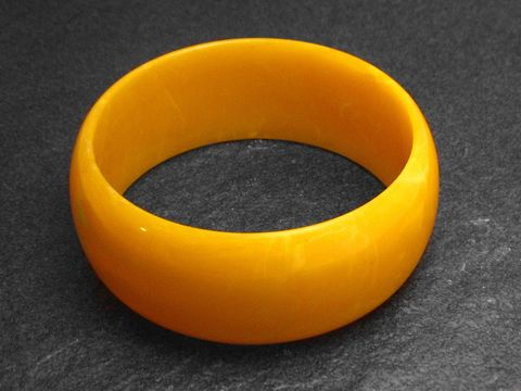 Plastik Schmuck Armreifen in bernsteinfarben mit einem Durchmesser von 3 cm, Hersteller Juwelier Harnisch, eleganter und einfacher Designstil für jeden Anlass.
