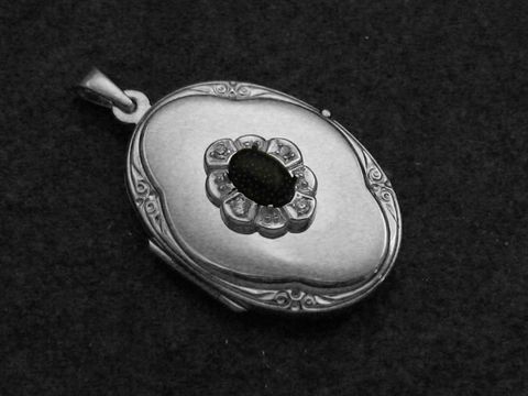 Medaillon Cabochon in rhodiniertem Sterling Silber mit verzierter Fassung, Zentrum mit schwarzem Stein und umlaufenden kleinen Ziersteinen, hergestellt von Juwelier Harnisch.