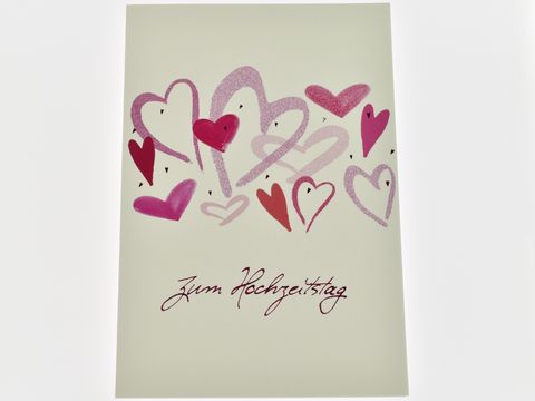 Hochzeitskarte mit bunten Herzen in verschiedenen Größen und Farben, darunter rote und pinke Herzen, mit der Aufschrift zum Hochzeitstag, Hersteller Juwelier Harnisch.
