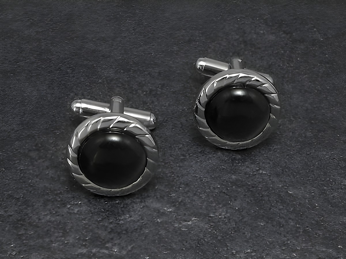 Manschettenknöpfe in grau mit einem besonderen Design von 17 mm Durchmesser, silberfarben mit einer runden, dunklen Einlage, hergestellt von Juwelier Harnisch.