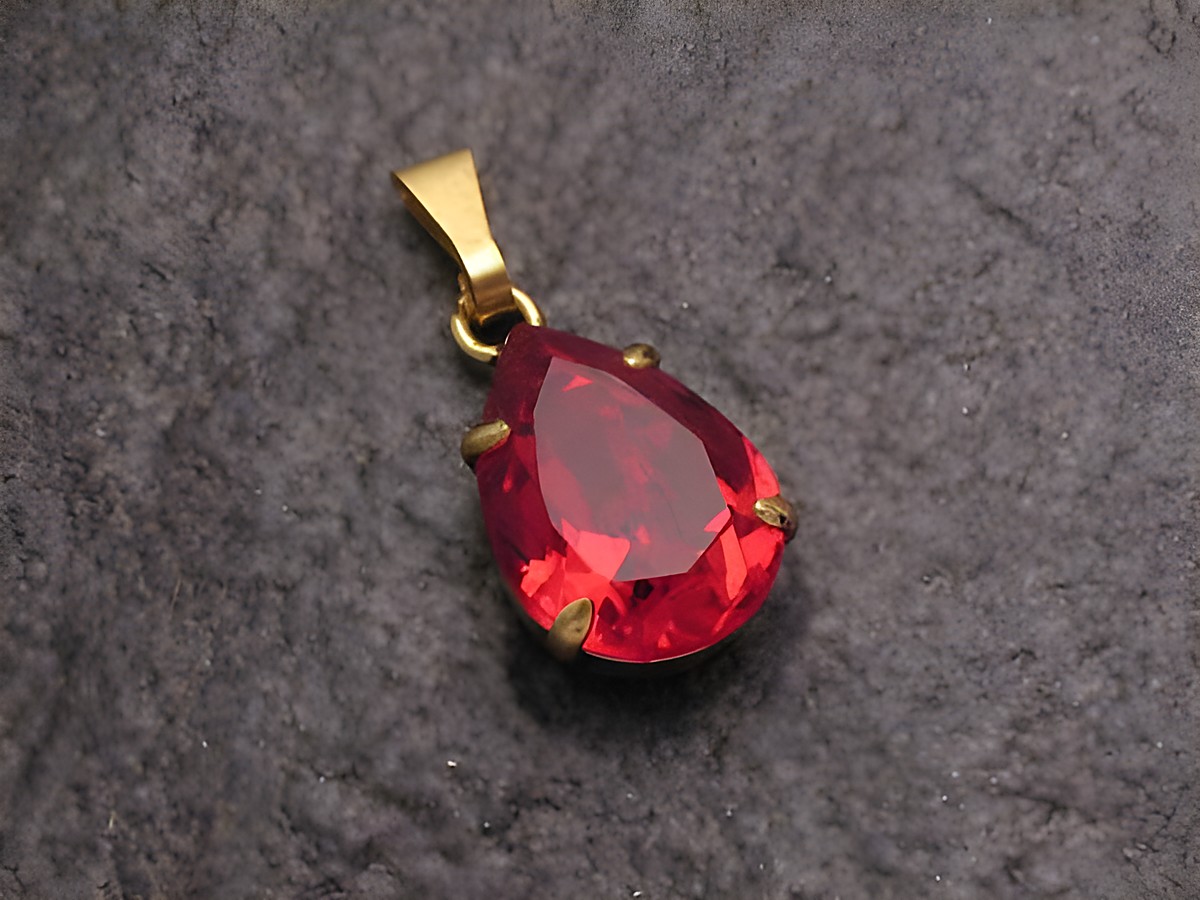 Roter Strass Anhänger in Tropfenform mit goldener Öse, ideal für einen sexy City Look, hergestellt von Juwelier Harnisch, erhältlich in weiteren Formen.