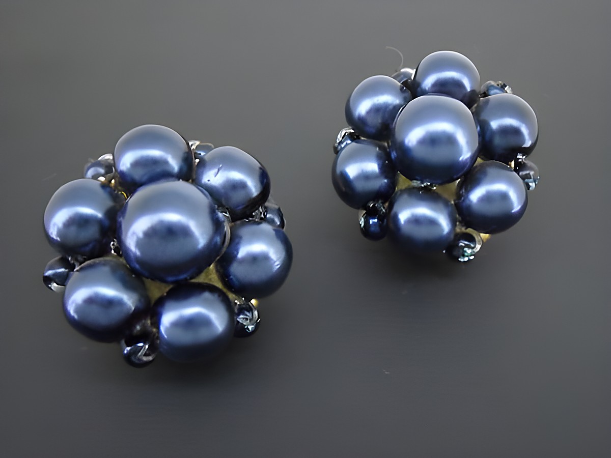 Dunkelblaue blumige Ohrclips mit goldfarbenen Elementen und synthetischen Zuchtperlen, hergestellt von Juwelier Harnisch.