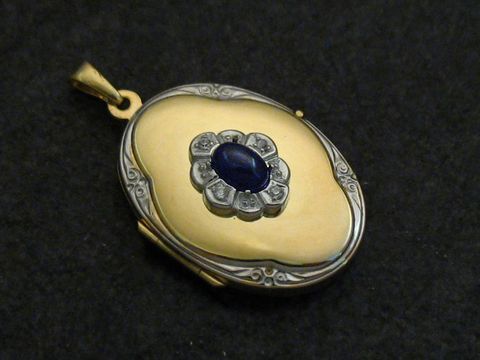 Medaille aus Gold 333 bicolor mit einem blauen Cabochon-Saphir, umgeben von Brillanten. Hersteller Juwelier Harnisch. Elegantes Schmuckstück für besondere Anlässe.