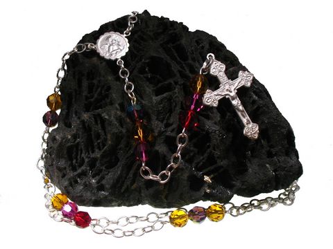 Kristall Rosenkranz mit Schutzengel Kreuz in 54 cm Länge, hergestellt von Juwelier Harnisch. Die bunten, glänzenden Perlen verleihen dem Rosenkranz einen besonderen Charme.