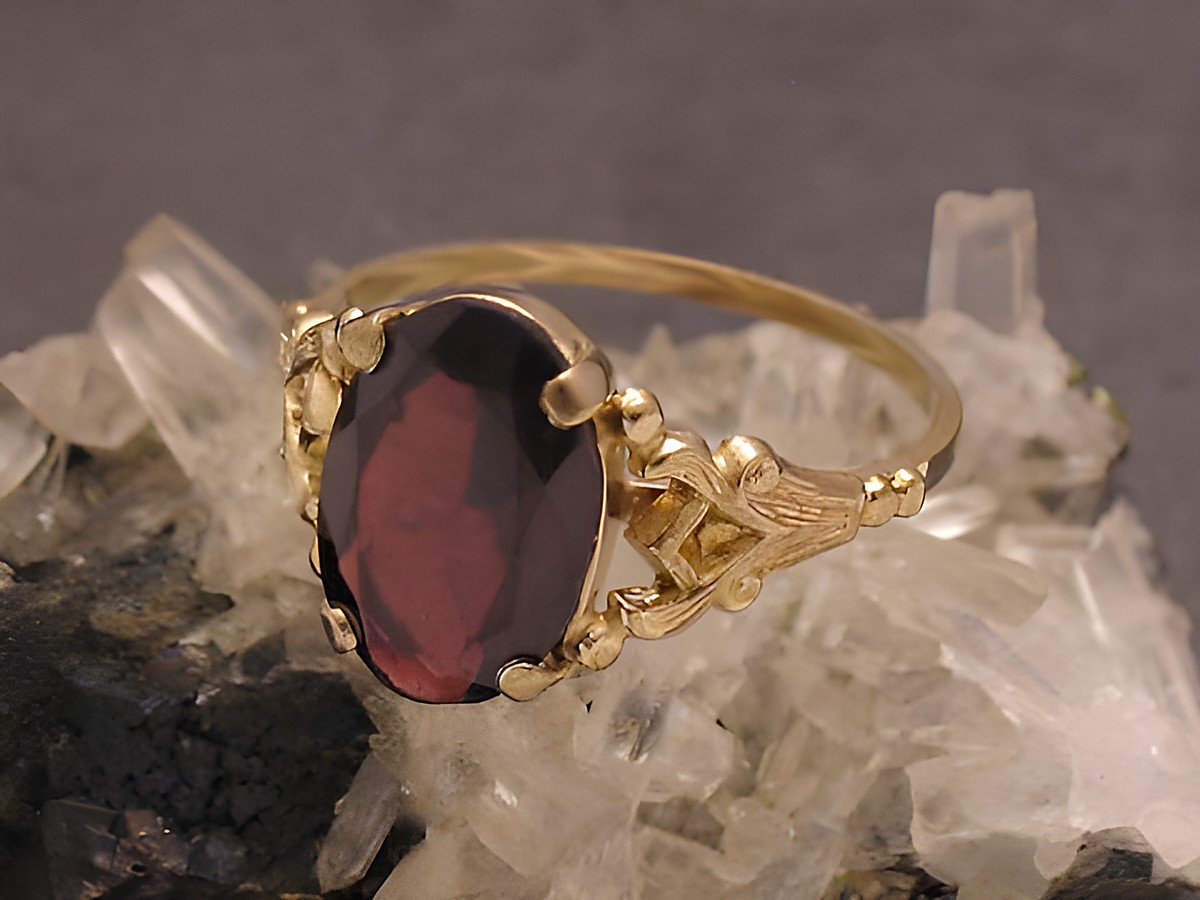 Goldring prächtig Gold 333 mit Granat in Größe 57, Hersteller Juwelier Harnisch, geeignet bis Größe 58/18,5, auf Kristalluntergrund präsentiert.
