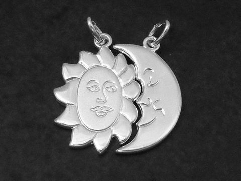 Zwei Silberanhänger in Form von Sonne und Mond, verbunden durch ein gemeinsames Design, symbolisieren Freundschaft und Harmonie, hergestellt von Juwelier Harnisch.