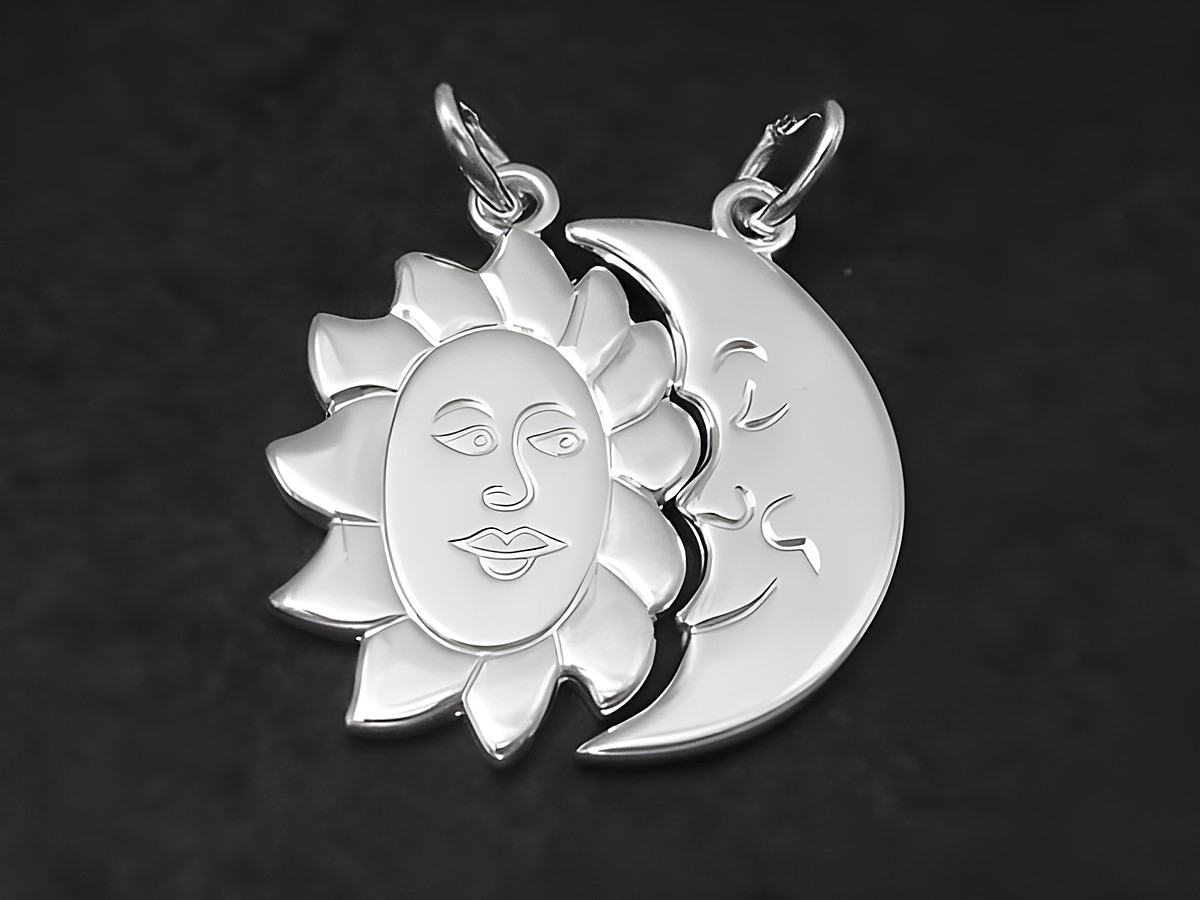 Zwei Silberanhänger in Form von Sonne und Mond, verbunden durch ein gemeinsames Design, symbolisieren Freundschaft und Harmonie, hergestellt von Juwelier Harnisch.