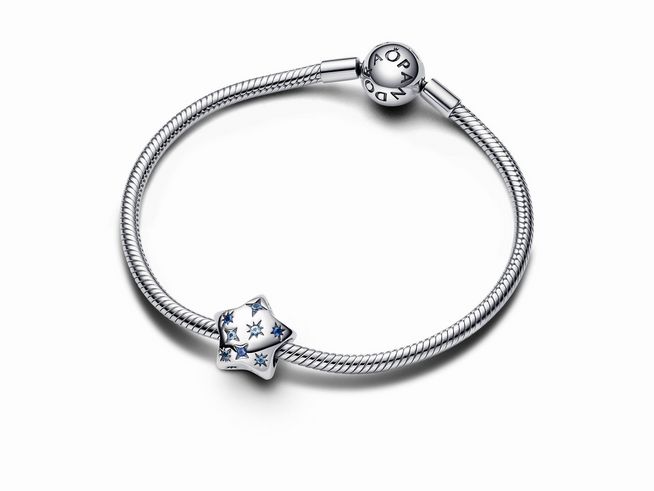 Auf dem Bild ist ein eleganter Pandora Charm aus Sterling Silber mit einem auffälligen, funkelnden Stern-Design in blauem Kristall zu sehen. 