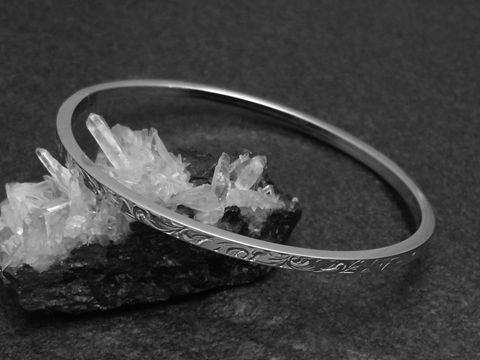 Silber Armreifen mit Ornamenten, 3 mm dick, rhodiniert, 18 cm lang, stylisch auf schwarzem Untergrund mit Kristallen präsentiert, Hersteller Juwelier Harnisch.