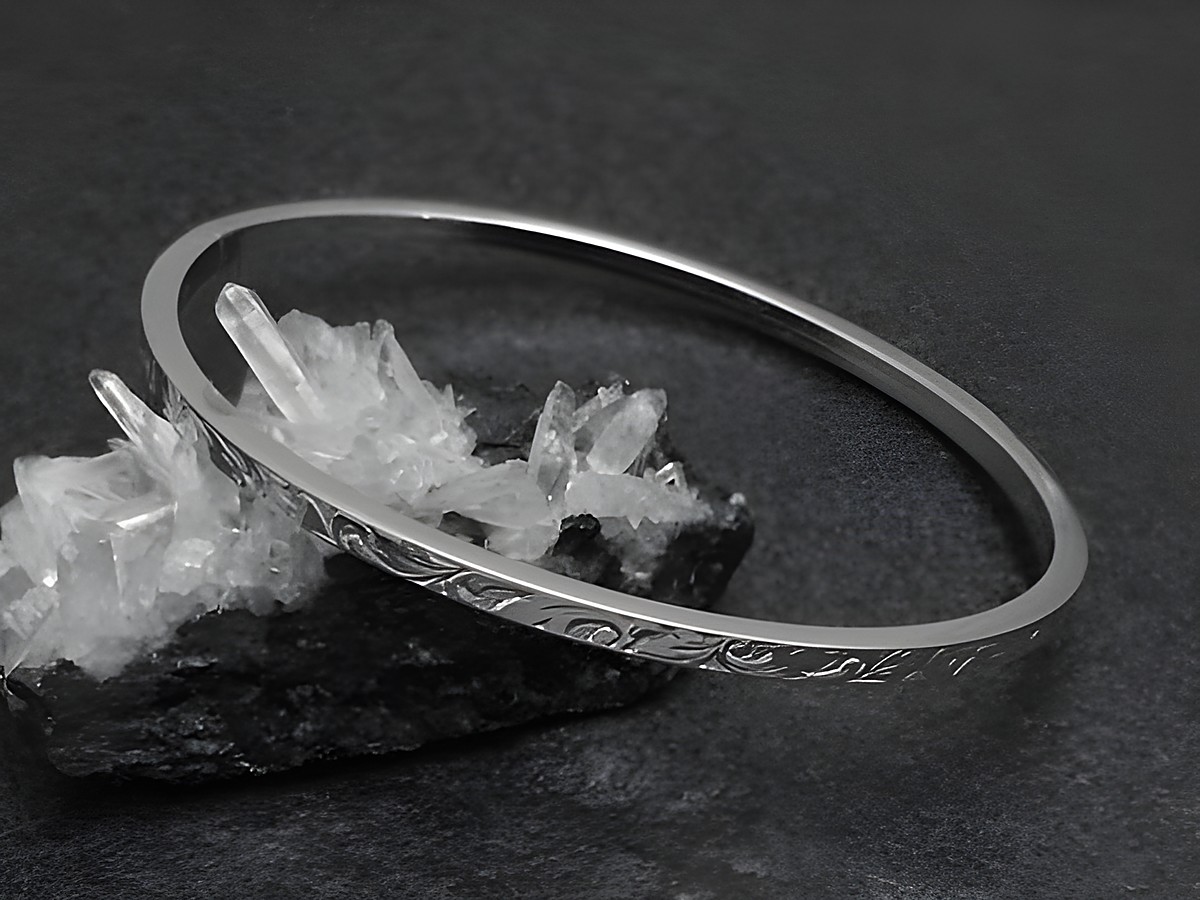 Silber Armreifen mit Ornamenten, 3 mm dick, rhodiniert, 18 cm lang, stylisch auf schwarzem Untergrund mit Kristallen präsentiert, Hersteller Juwelier Harnisch.