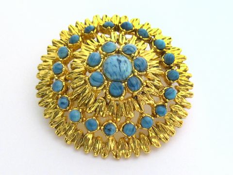 60085-0 Damen Brosche im Sexy City Look in Blau rund, Hersteller Juwelier Harnisch, Broschen in Türkis Look mit goldener Umrandung und verschiedenen turquoisefarbenen Steinen.