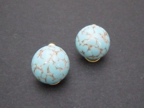 Ohrclip in klassischem Design mit türkisfarbenen, synthetischen Kugeln und goldfarbenem Rahmen, Hersteller Juwelier Harnisch, zeitlos und elegant.