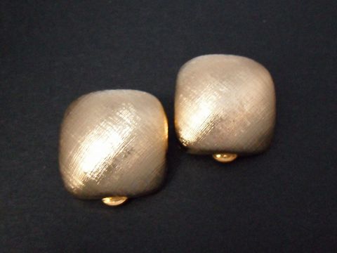 Zeitlose Ohrclips in goldfarbener Echtheit mit einer glatten, strukturierten Oberfläche. Hersteller Juwelier Harnisch, perfekt für jeden Anlass und tragbar zu verschiedensten Outfits.