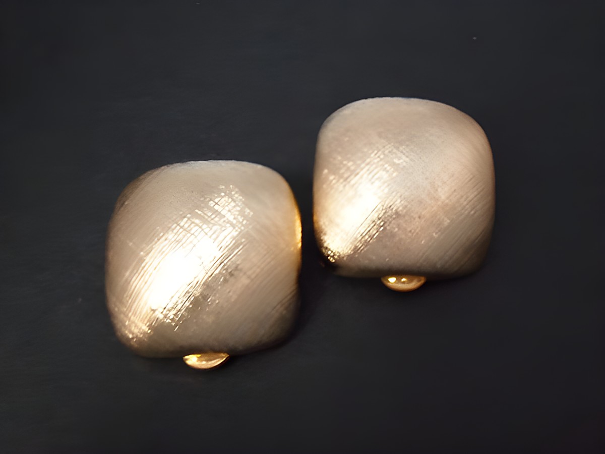 Zeitlose Ohrclips in goldfarbener Echtheit mit einer glatten, strukturierten Oberfläche. Hersteller Juwelier Harnisch, perfekt für jeden Anlass und tragbar zu verschiedensten Outfits.