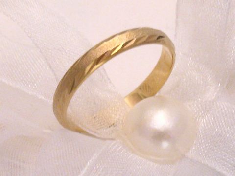 Trauring Ehering NEW SMARTY in Gold 333 mit einer Breite von 3 mm. Der Ring hat eine attraktive Struktur und ist mit einer Perle auf einem weißen Stoffband präsentiert. Er eignet sich bis Größe 64.