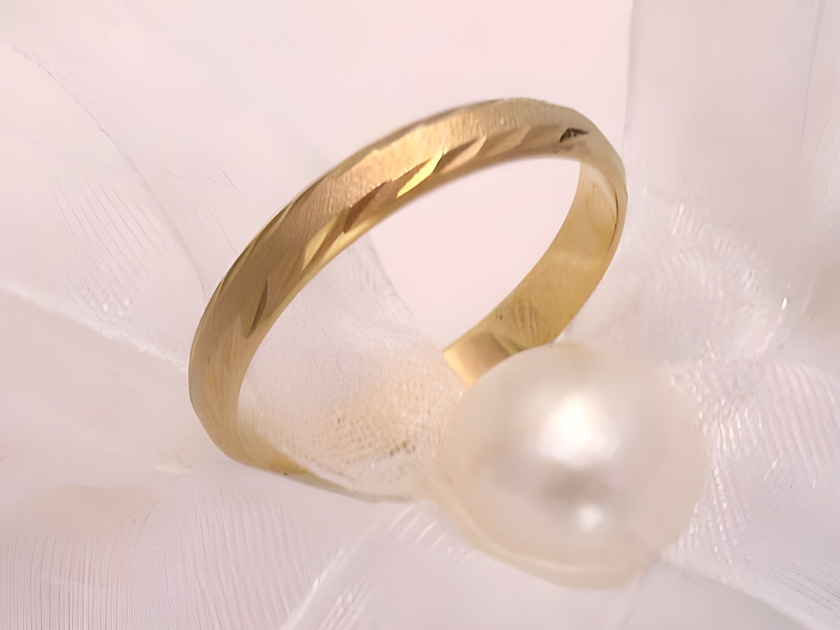 Trauring Ehering NEW SMARTY in Gold 333 mit einer Breite von 3 mm. Der Ring hat eine attraktive Struktur und ist mit einer Perle auf einem weißen Stoffband präsentiert. Er eignet sich bis Größe 64.