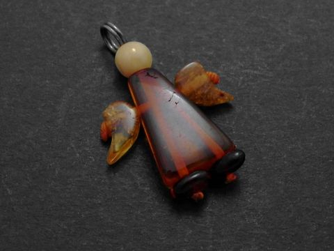 Engel Anhänger aus dunkelbraunem und bernsteinfarbenem Material mit schützenden Flügeln, Hersteller Juwelier Harnisch, idealer Bernstein Schmuck für besondere Anlässe.