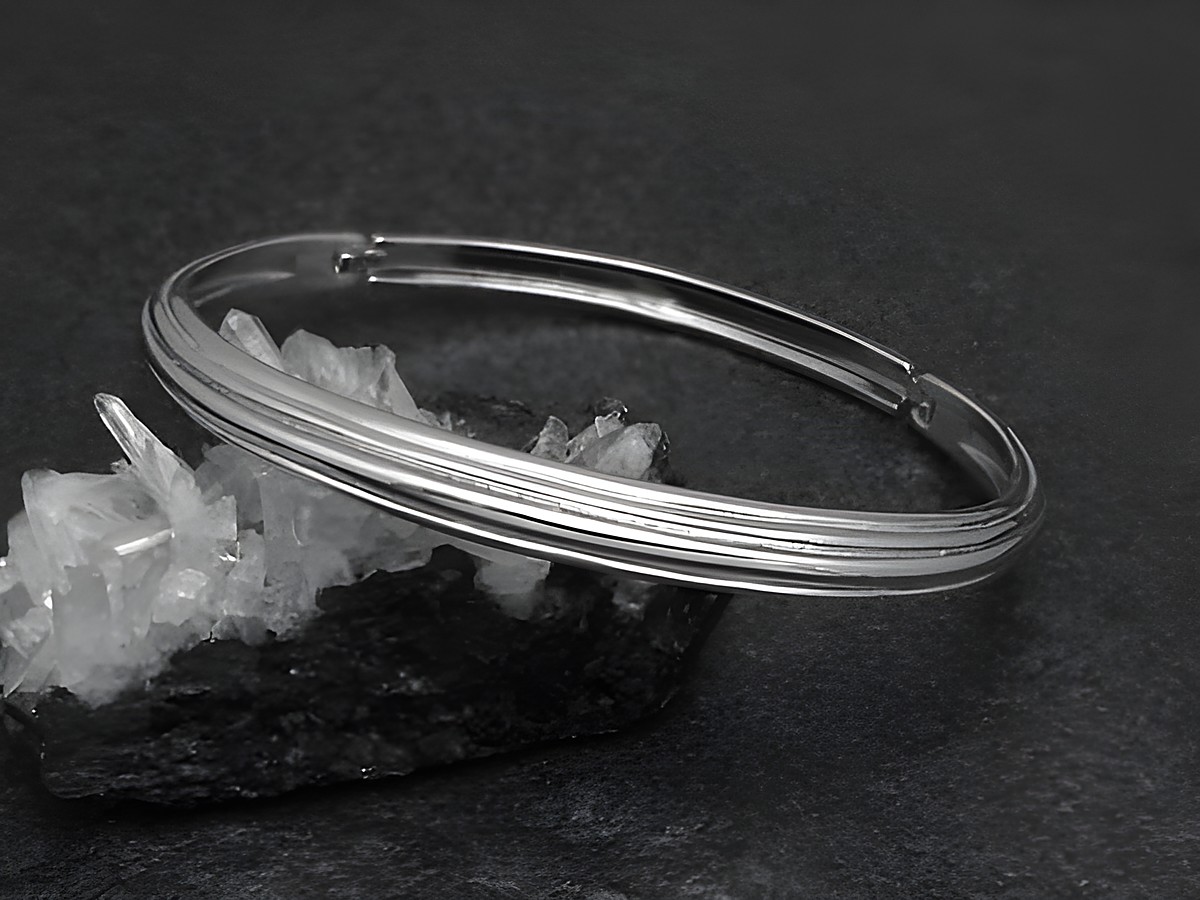 Silber Armreifen weiblich 6 mm rhodiniert 16,5 cm von Juwelier Harnisch, elegant auf schwarzem Hintergrund mit Kristallen drapiert. Ideal für stilvolle Akzente.